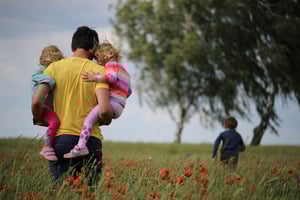Father holding children after mother suddenly passed away, dealing with finacial burden left begind. 